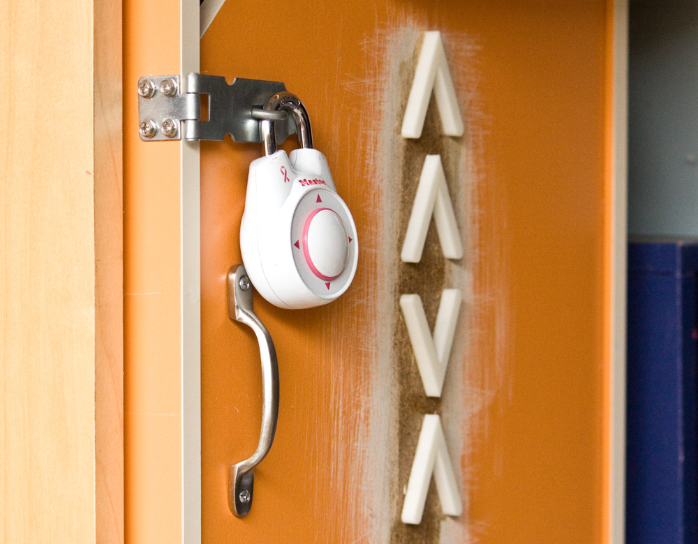 Pictured is a cupboard locked with a directional padlock. Not far from the lock itself, is column of arrows. In order, these arrows point up, up, down and up.